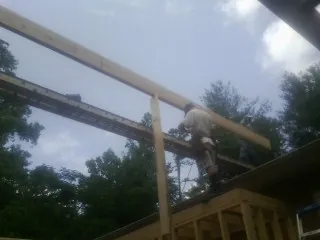 Carpenter setting a ridge beam over a new addition frame — Ice Dam Removal by Roofing Brothers in Lafferty