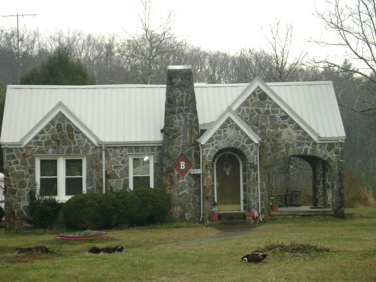 White metal roof on a stone cottage with steep gables in Lafferty